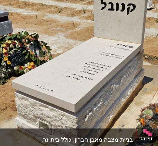 מצבה עם כיתוב בעברית וזרי פרחים